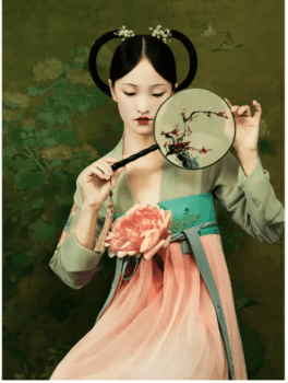 一位穿着精美丝绸的中国女子抱着扇子